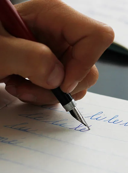 Pluma escribiendo sobre papel