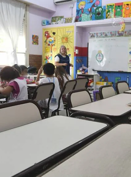 Salón de escuela con maestra y niños
